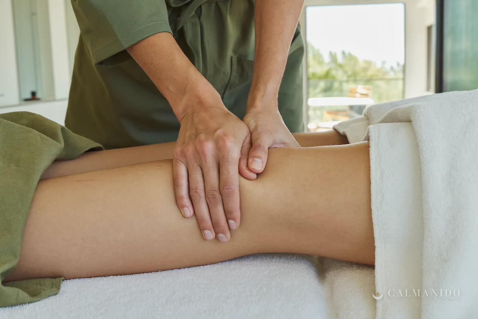 A beauty therapist's hands giving a drainage massage on a leg