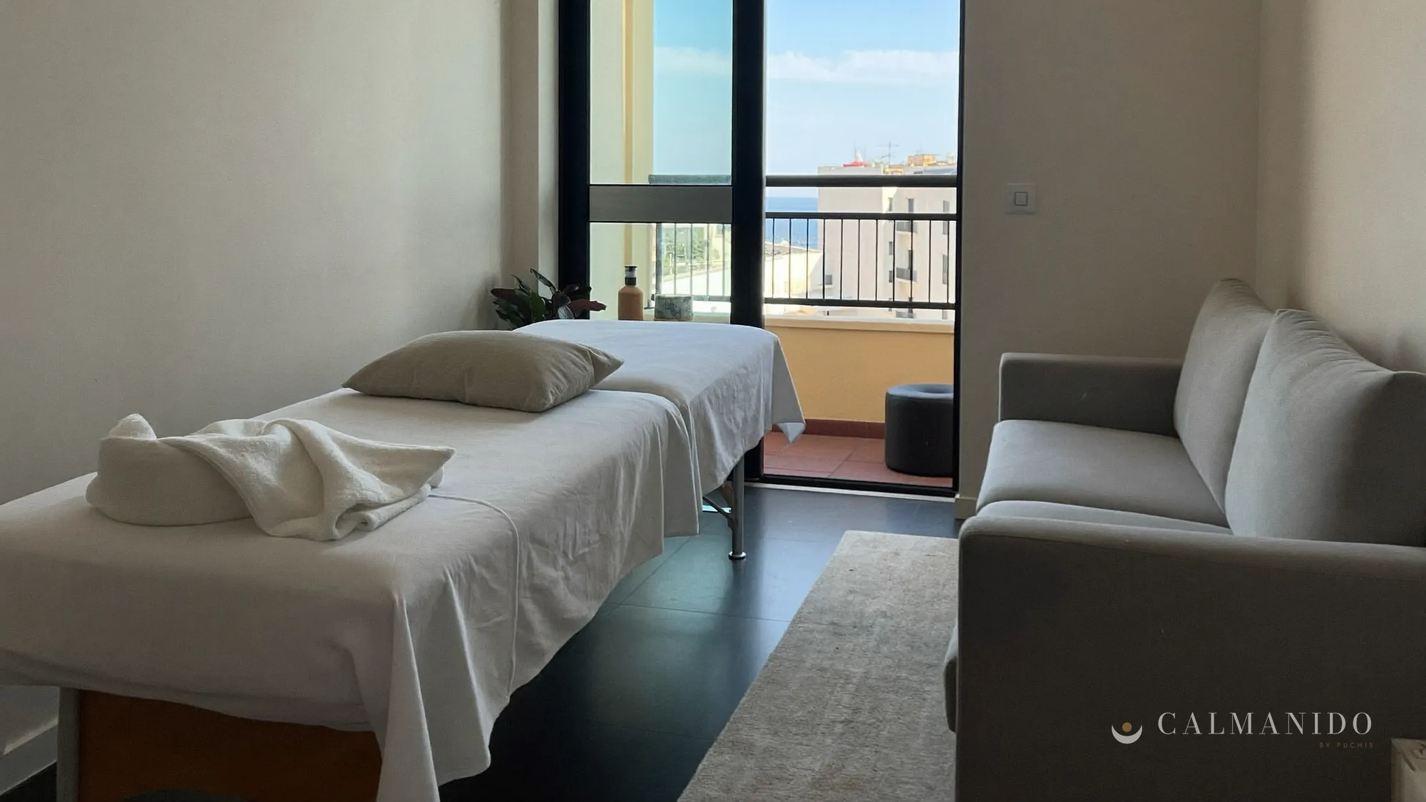 A therapist setting up a massage table in the bedroom of a flat